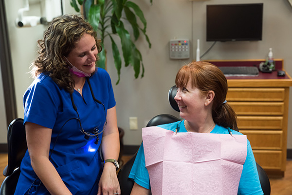 A nurse talking to a female patient in a hospital room.